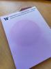 Purple-toned circular sunspot on formerly white notepad paper.