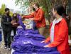 Purple t-shirts on tables, with staff distributing them to UW Tacoma students.