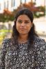 Anindita stands outside in a black and white blouse.