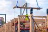 Crane lowers cross-laminated panel into place for Milgard Hall.