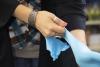 The hands of Dr. Anna Groat Carmona, shown pulling on blue latex gloves.