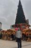 Jovany stands in front of a large Christmas tree in a German market