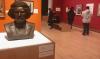 AMC students in an art gallery with a large bronze sculpted head in the foreground