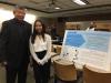 student and professor standing in front of colloquium poster