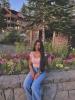 Girl sitting on a ledge with flowers e