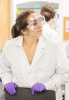 Photo of a student in a lab coat and safety goggles