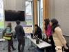 Photo of a group of students presenting their project poster to a professor