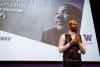 Man standing in front of image of MLK giving speech