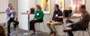 Panelists discuss the business of clean energy in front of an audience of students