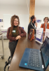 Student smiling with another student and professor in the background