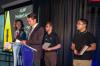 OSCARS Image: One man presenting an award for three students standing at his back