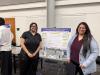 Photo of two students standing next to their research poster