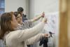 Two women pointing at sketch of map on a whiteboard