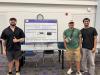 Photo of 3 students standing in front of their group poster board
