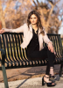 Photo of Mannat Sudan sitting on a bench, arm lain across the back of the bench and facing the camera