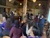A large, diverse group of students fills the lobby of a local coffee shop.
