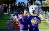 Hendrix the Husky, UW Tacoma's mascot, takes a photo with a student at UW Tacoma Convocation.