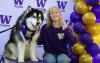 A UW Tacoma student takes a photo with Dubs, a malamute that serves as UW's live mascot.
