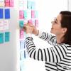 Person putting sticky notes on wall