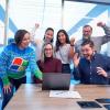 team of happy people looking at a laptop