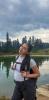 OGA Fellow Valeria hiking in front of lake reflecting trees and sky